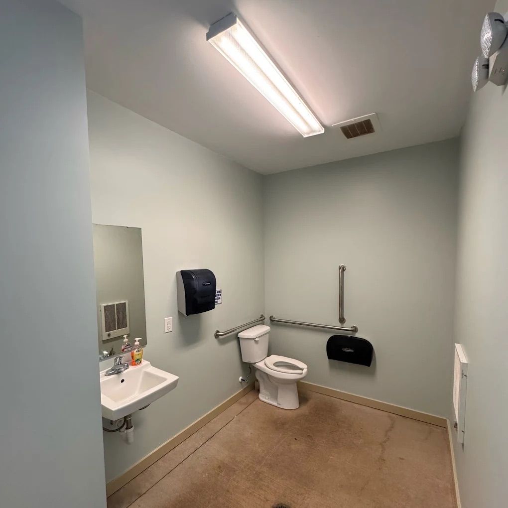 Commercial restroom with freshly painted soft green-gray walls